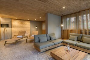 A modern living room with a wooden ceiling, a sofa set, a coffee table, and a TV on a stand. - Holiday apartment with 1 bedroom (Oberstdorf)