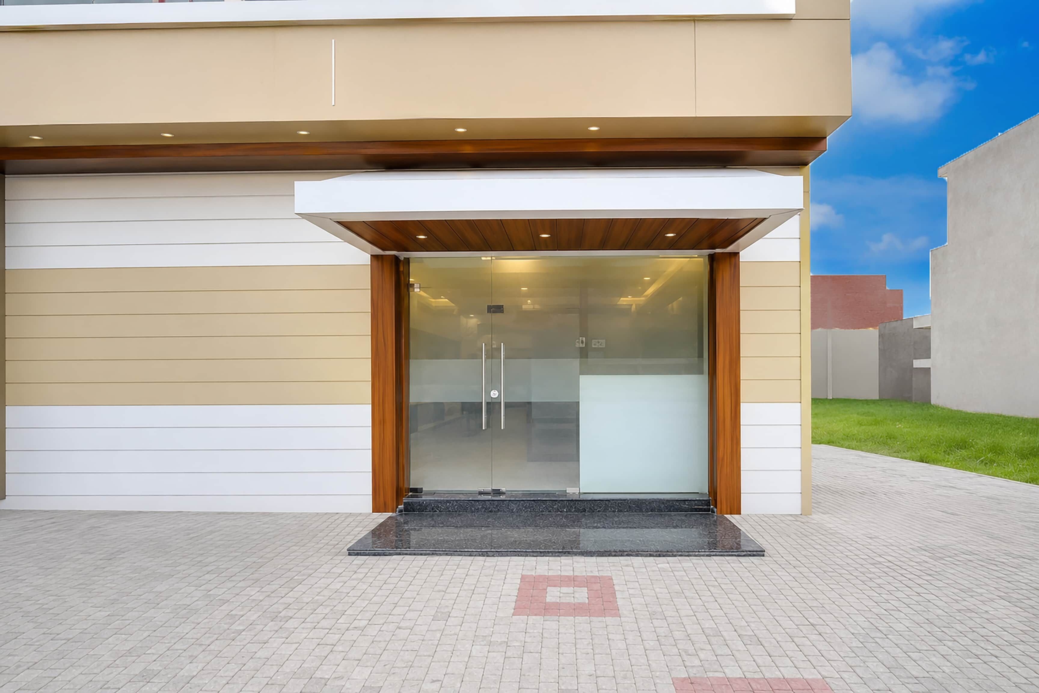 A modern building entrance with a glass door and a wooden overhang.