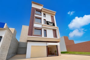 A modern townhouse with a garage, a sign indicating it is a townhouse, and a clear blue sky in the background. - Townhouse Kurukshetra University (Kurukshetra)