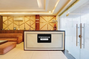 A reception area with a reception desk, a couch, and a wall-mounted air conditioner.