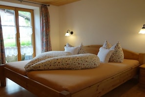 A bedroom with a bed, curtains, and wall-mounted lights. - in the Vogler House Apartment (Bad Hindelang)