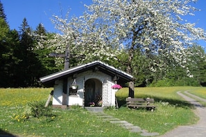 A small chapel with a white exterior, a wooden door, and a bench nearby. - Organic farm with 2 bedrooms (Missen-Wilhams)
