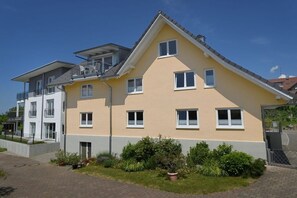 A multi-story residential building with a balcony, a flat roof, and a well-maintained garden. - A Country House Dinkelbach Object 1 (Lindau-Bodolz)