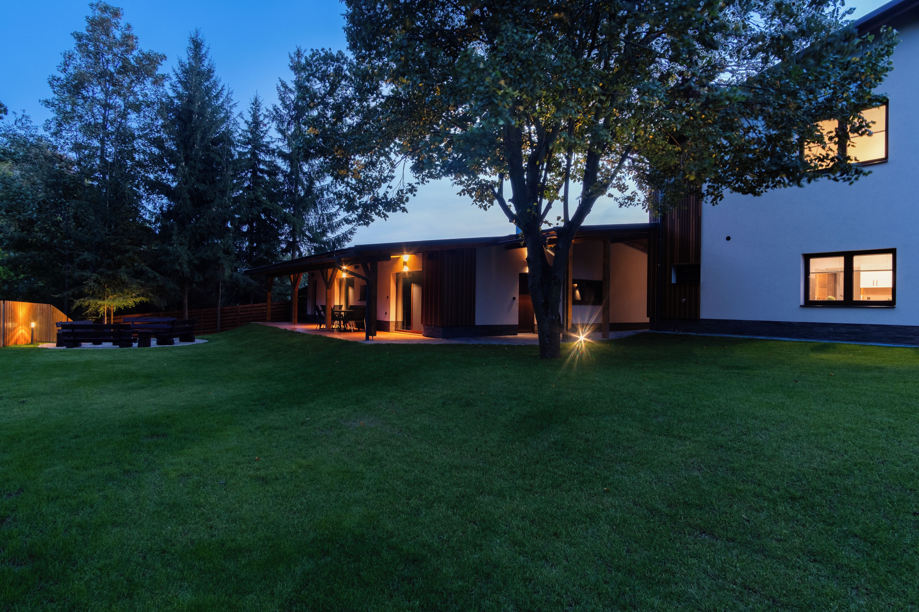 A modern house with a well-maintained lawn and a patio area.