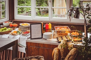 A buffet setup with various food items and a menu board. - Horský hotel Sepetná (Ostravice)