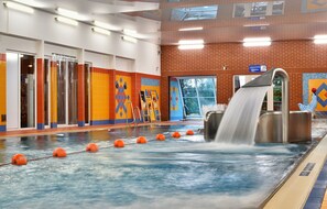 A water slide in a public indoor facility with a tiled floor and a brick wall. - Horský hotel Sepetná (Ostravice)