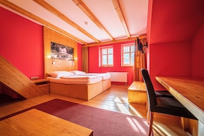 Un dormitorio con una cama de madera, un escritorio, una silla y una ventana con cortinas.
