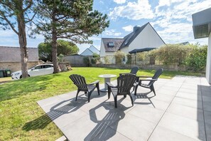 A patio with outdoor furniture and a lawn. - Beautiful house between Ocean and Countryside by Groom* (Guidel)
