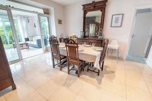 A dining area with a large table, chairs, and a mirror. - Breton family home, within walking distance of the beach – by Groom* (Ploemeur)