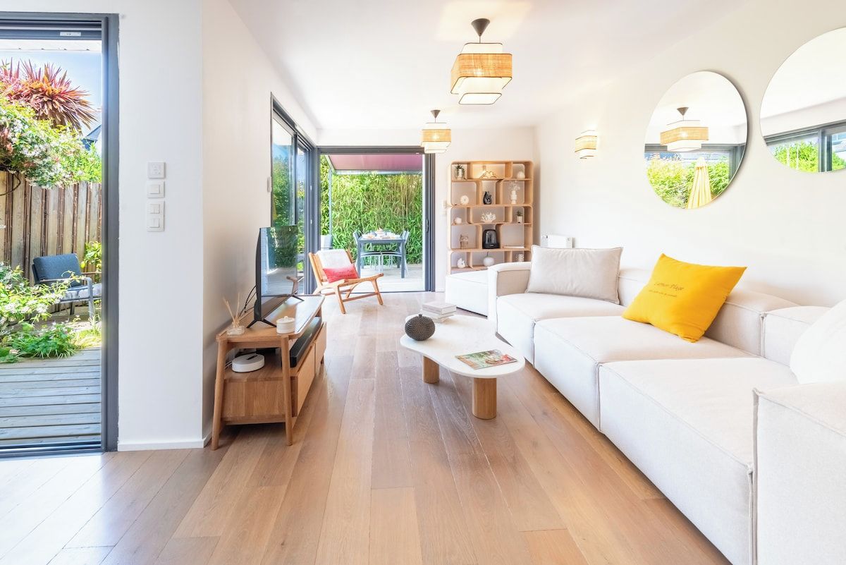 A modern living room with a sofa, coffee table, and a bookshelf.