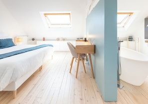 A bedroom with a bed, a desk, a chair, a window, and a bathroom with a bathtub. - Stunning Premium Villa, beaches within walking distance via Groom* (Larmor-Plage)