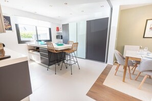 A modern kitchen with a dining area, large windows, and a sliding door. - Stunning Premium Villa, beaches within walking distance via Groom* (Larmor-Plage)