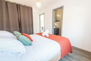A hotel room with a bed, curtains, a door, and a view of the outside. - Charming house 2 minutes from the beaches, by Groom* (Ploemeur)