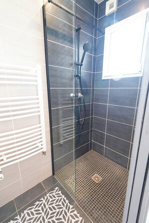 A glass-enclosed shower with a handheld showerhead and a wall-mounted control. - Charming house 2 minutes from the beaches, by Groom* (Ploemeur)