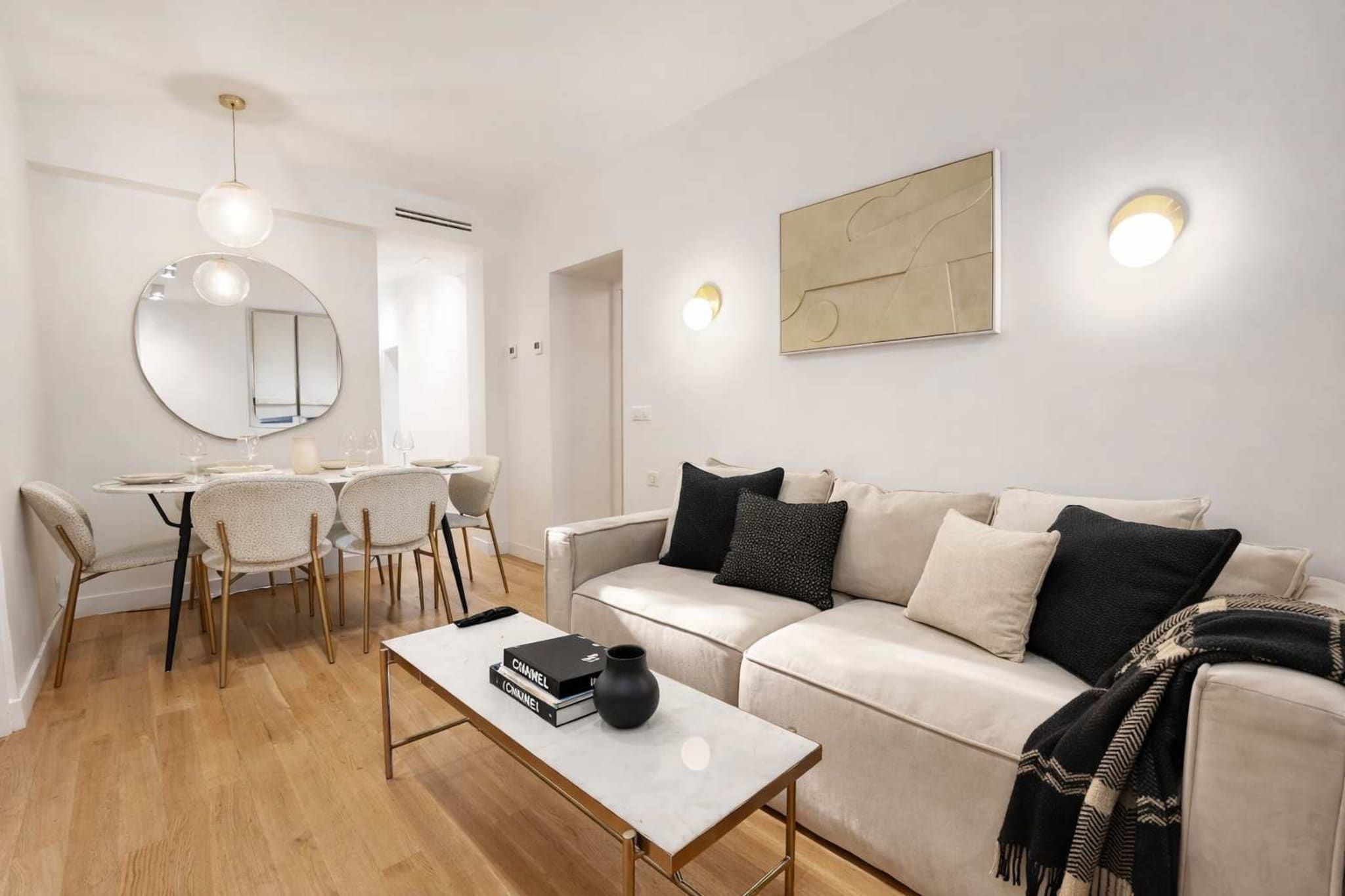 A modern living room with a sofa, coffee table, and dining area.