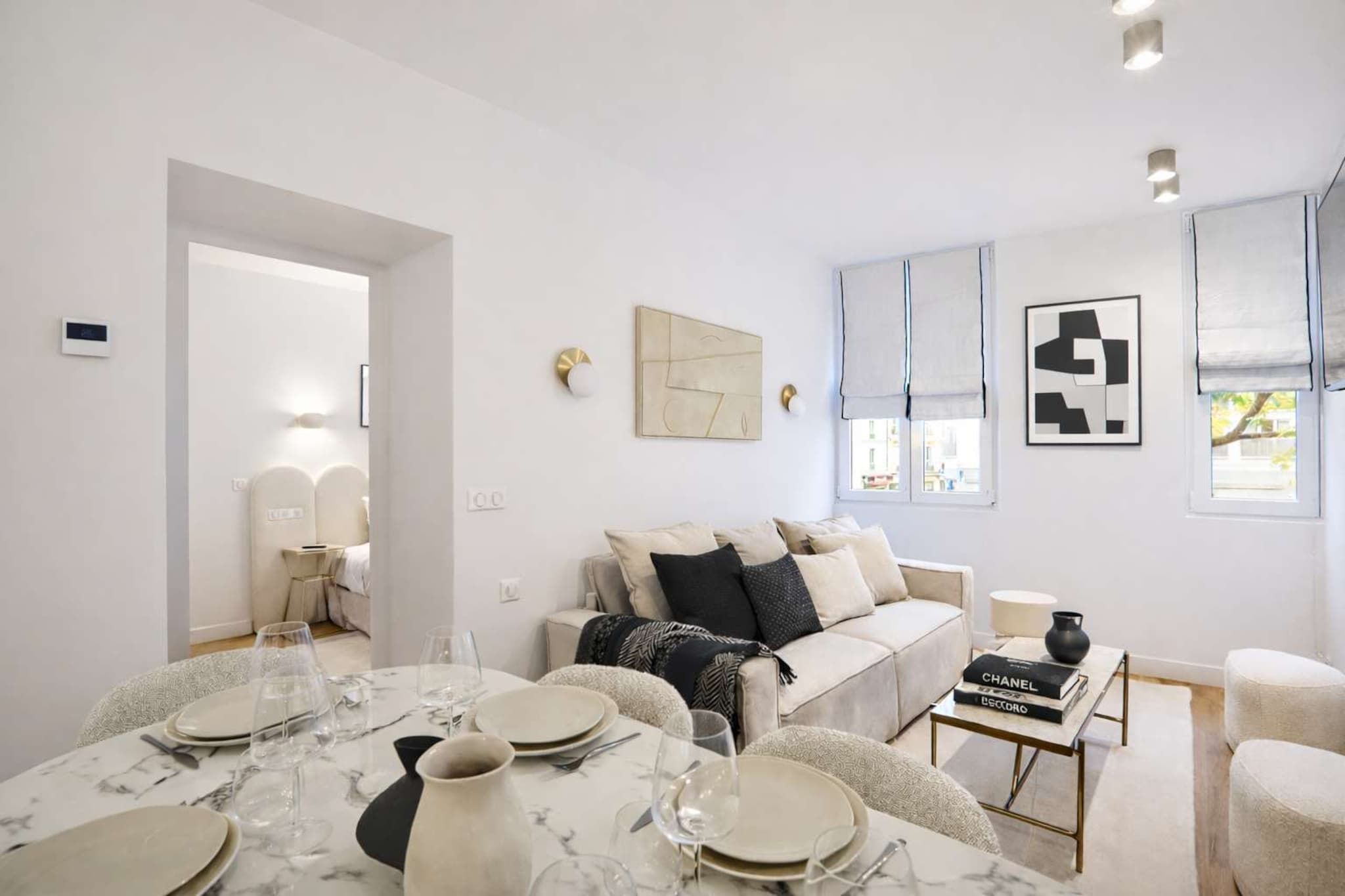 A modern living room with a dining area, a sofa, and a coffee table.