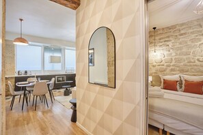 Een moderne keuken met een eethoek, een stenen muur en een gezellige zithoek met kussens.