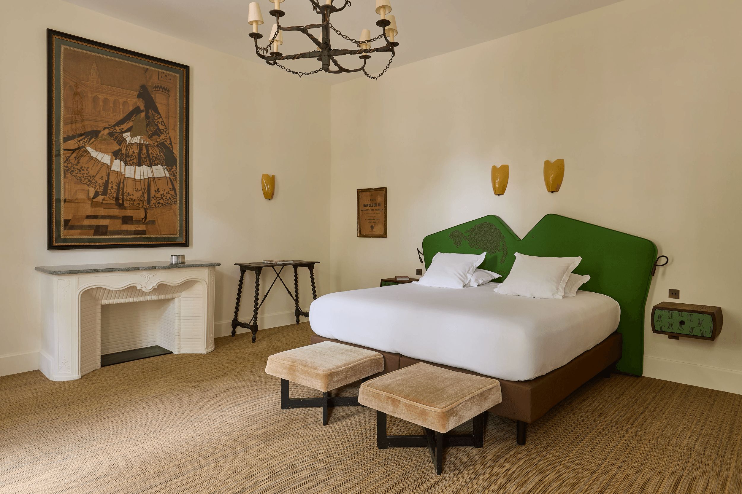 Un dormitorio con cama, un cuadro, una chimenea, una mesa y una pared verde.