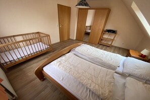 Ein Schlafzimmer mit einem Holckrippe, einem Doppelbett und einem Kleiderschrank.