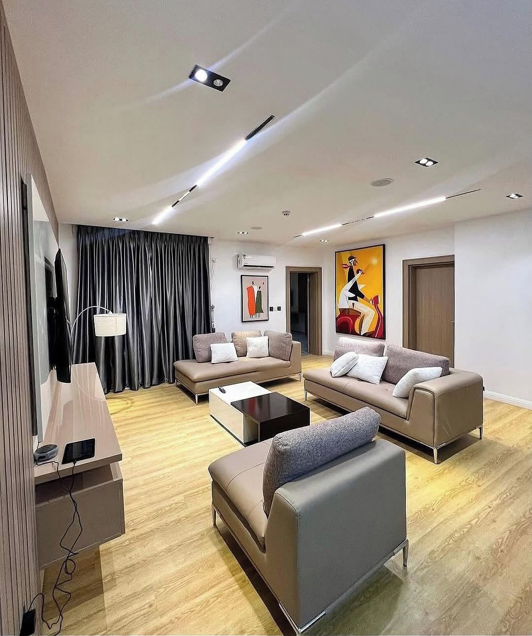 Una sala de estar moderna con dos sofás, una mesita de centro y un televisor.