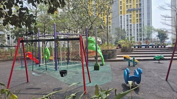 Une aire de jeux avec des balançoires, des toboggans et des structures d’escalade.