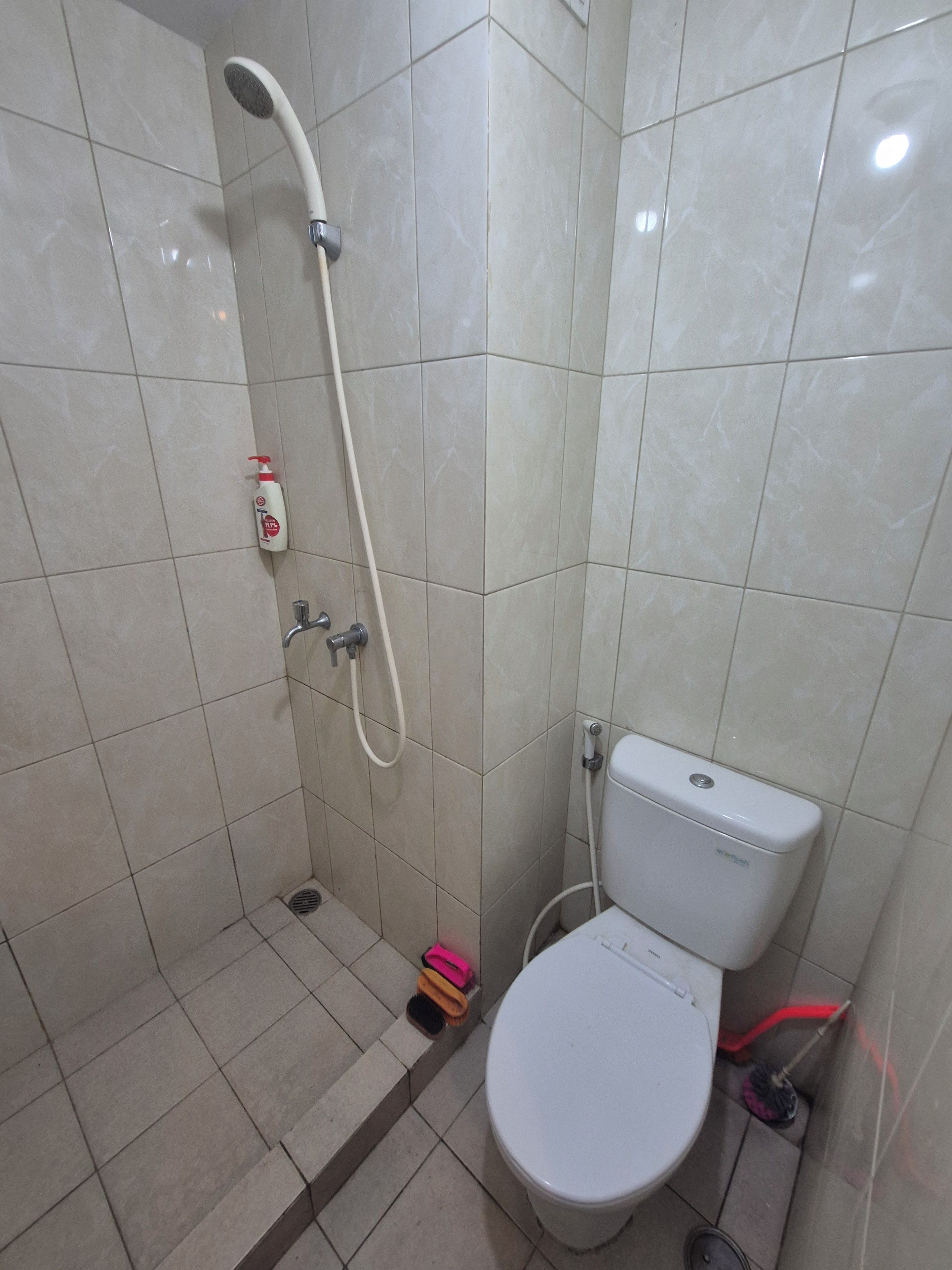 Ein Badezimmer mit Toilette, Dusche und einem Händetrockner.
