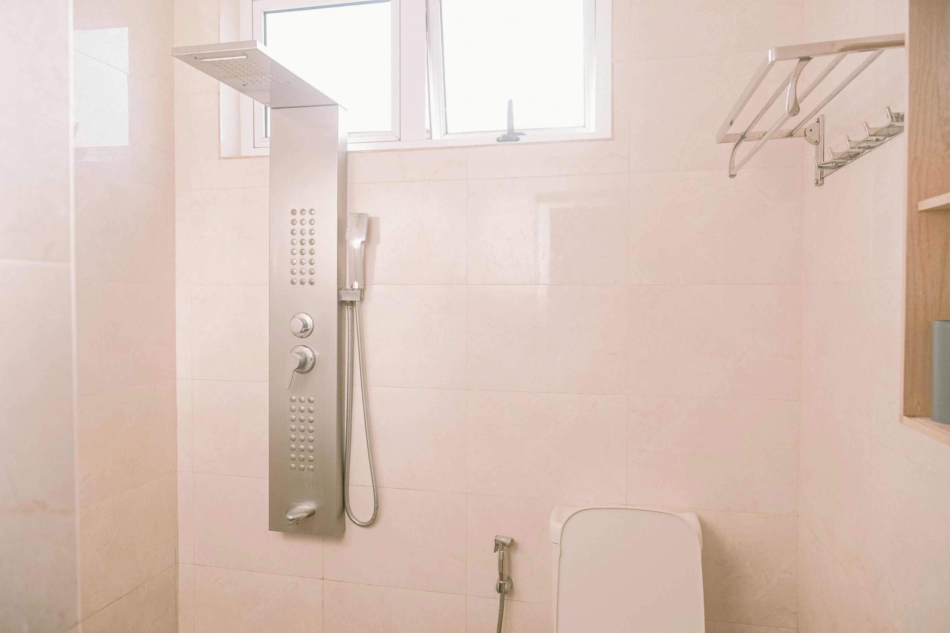 Une salle de bain avec une douche, des toilettes et une fenêtre.