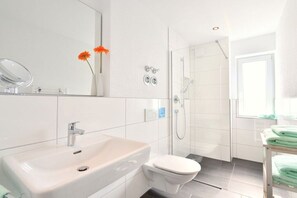 Ein modernes Badezimmer mit Waschbecken, Toilette und Dusche.