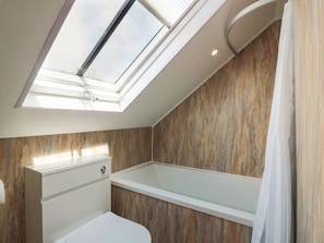 A modern bathroom with a skylight, a bathtub, and a vanity. - Olea (Stranraer)