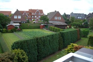 Een woonwijk met huizen, een verzorgd gazon en een haag.