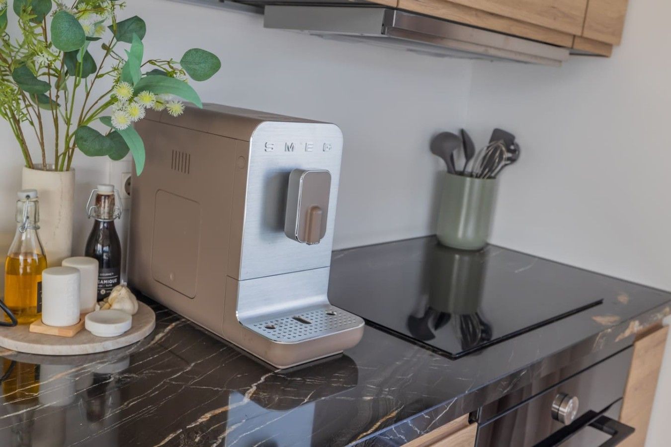 Een keuken met een koffiezetapparaat, een plant en diverse keukengerei.