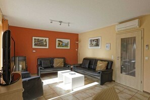 Ein Wohnzimmer mit zwei Sofas, einem Couchtisch und einem Fernseher.