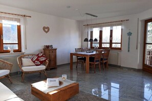 Amplia sala de estar con una mesa de comedor, sillas, un sofá y una mesa de centro.