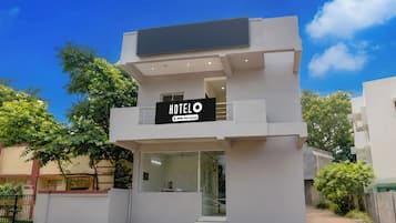 A modern hotel with a sign indicating it is serviced by OYO.