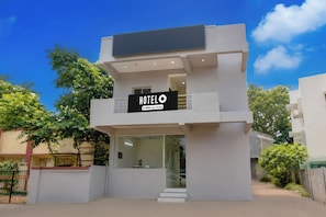A modern hotel with a sign indicating it is serviced by OYO.