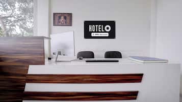 A hotel reception desk with a sign that reads 'HOTELO OYO-Serviced'.