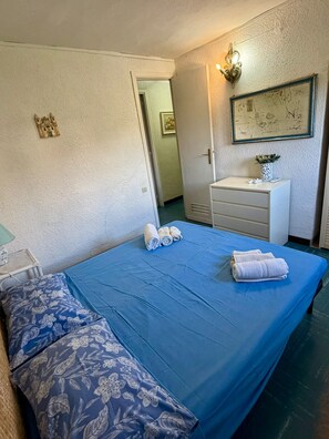 Ein Hotelzimmer mit einem Bett, einem Schminktisch, einem Spiegel und einer Wandleuchte.