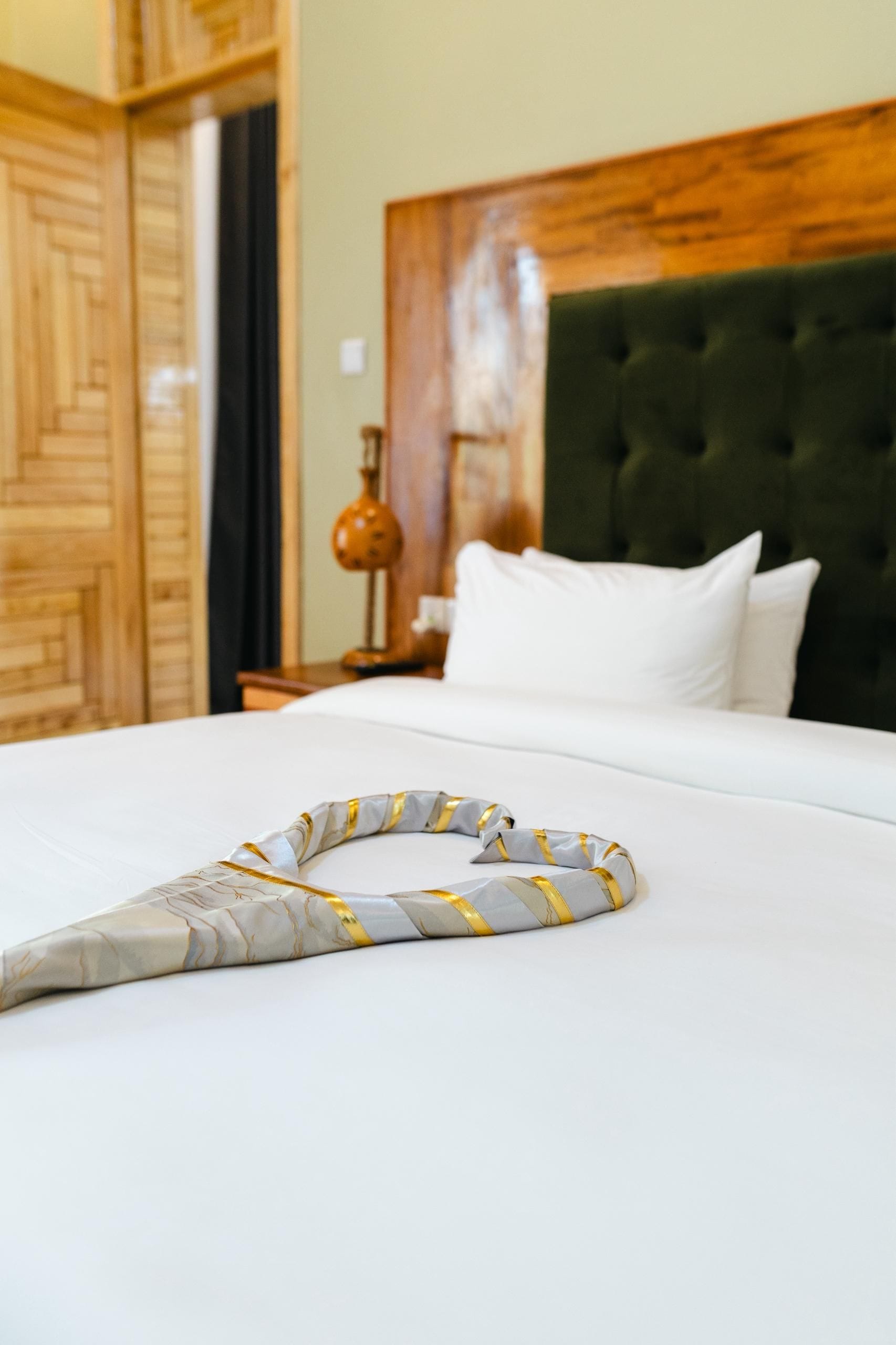 Una cama bien hecha con un objeto decorativo encima.