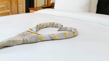 Una cama bien hecha con un objeto decorativo encima.