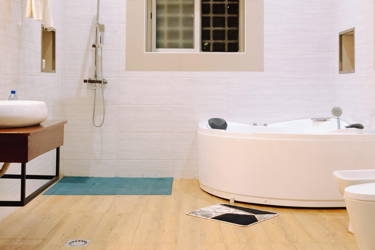 A modern bathroom with a freestanding bathtub, a vanity with a sink, and a shower area.