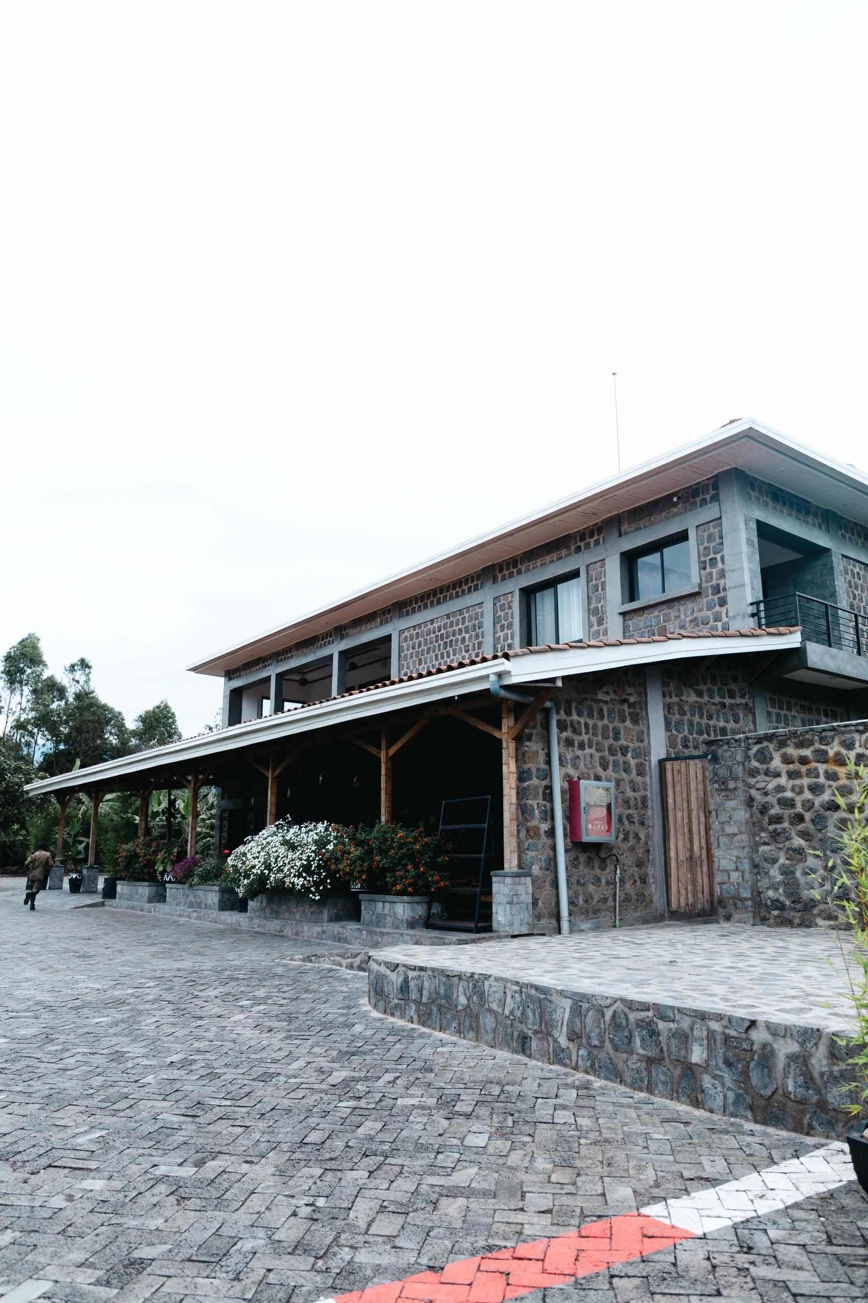 A stone building with a covered entrance and a paved courtyard.