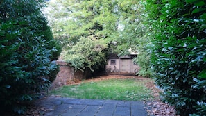 A paved pathway leading to a small shed with a bicycle parked outside. - Modern 2-Bed Flat, Bedford (Bedford)