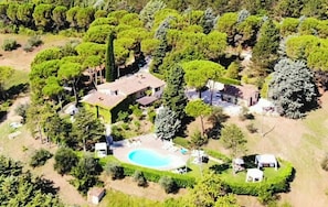 An aerial view of a residential property with a swimming pool, multiple buildings, and surrounding greenery. - Apartment with pool and views of medieval Gubbio (Gubbio)
