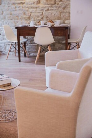A room with a wooden dining table set for two, surrounded by two upholstered chairs. - Apartment with pool and views of medieval Gubbio (Gubbio)