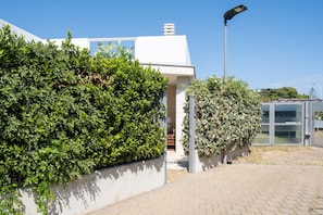 A modern building with a white facade, a large hedge, and a street lamp. - Villa Andrews by Wonderful Italy (Bari)