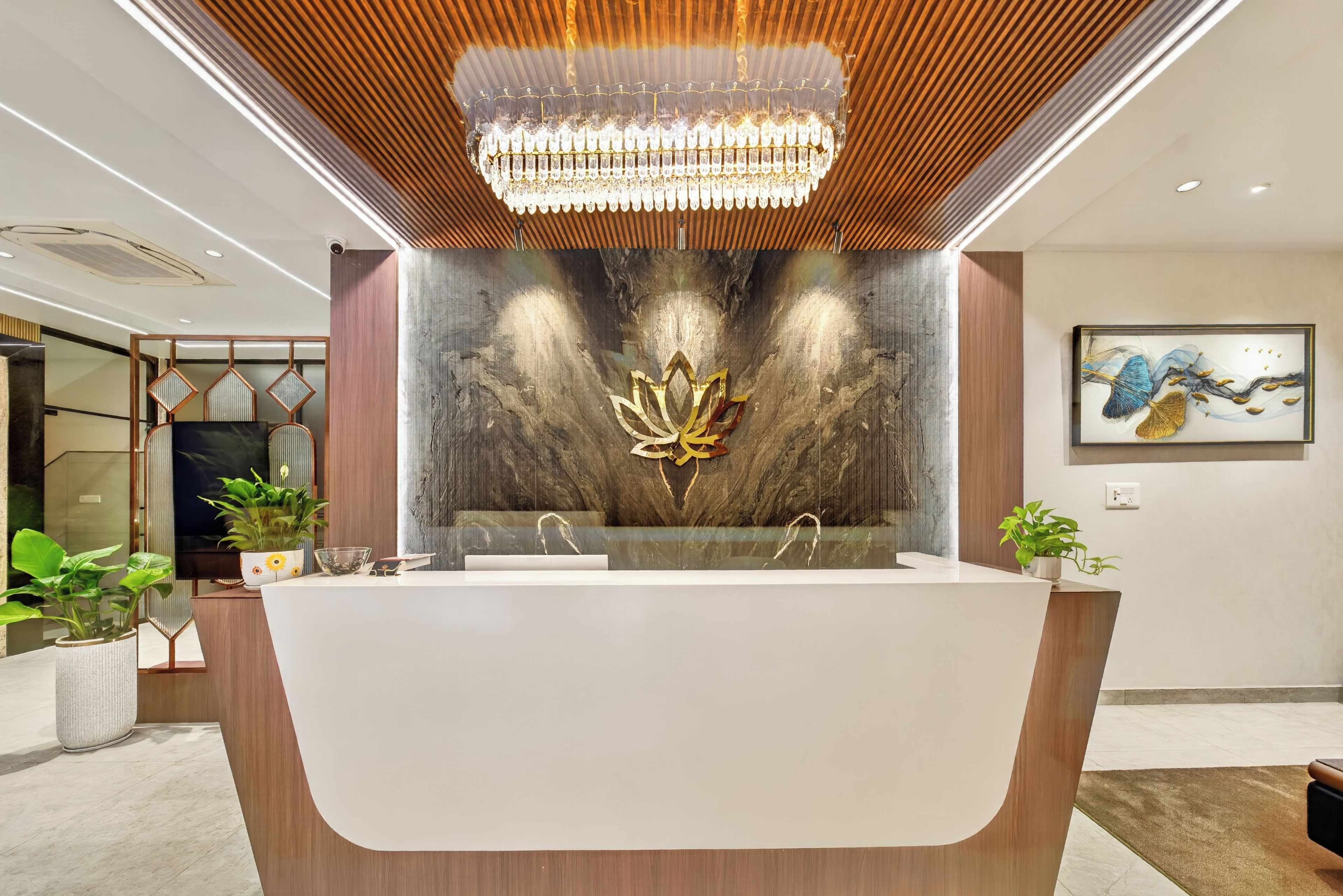 Un baño moderno con una bañera independiente, un revestimiento decorativo con diseño de loto y una araña.