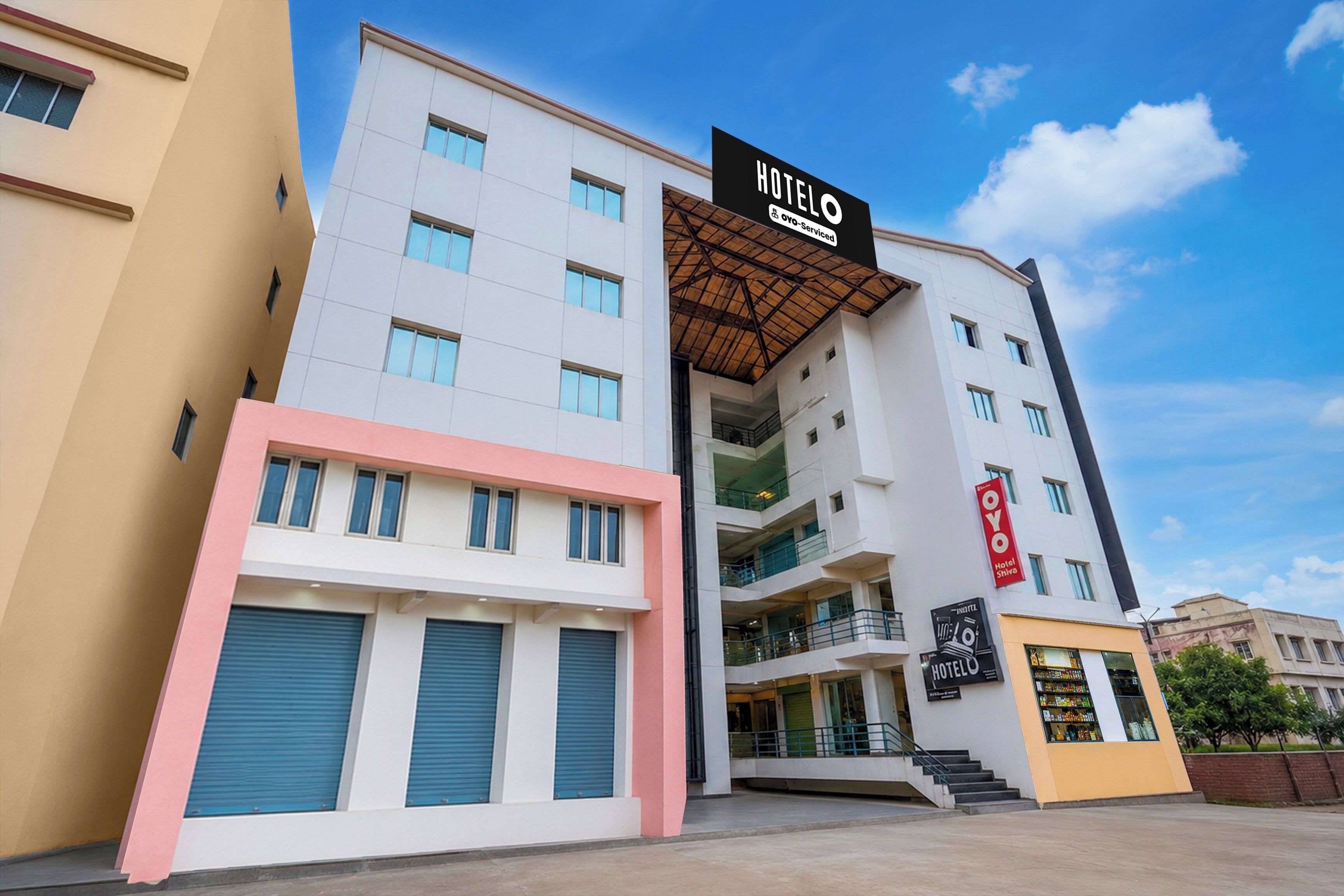 A multi-story hotel building with a prominent 'HOTEL' sign, a covered entrance, and a visible staircase leading to the entrance.