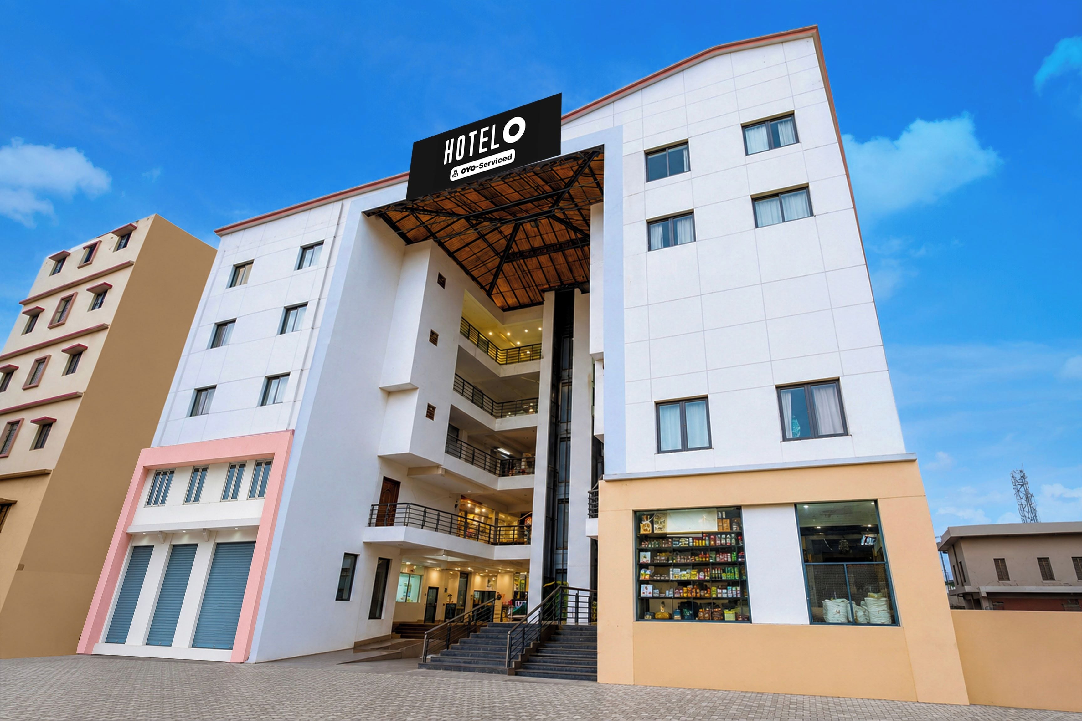 A multi-story hotel with a prominent entrance, balconies, and a visible ground floor retail space.
