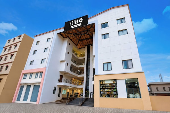 A multi-story hotel with a prominent entrance, balconies, and a visible ground floor retail space.