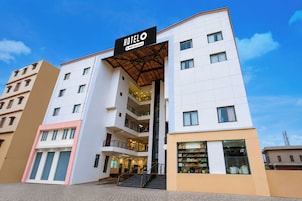 A multi-story hotel with a prominent entrance, balconies, and a visible ground floor retail space.